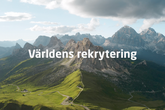 Bild tagen från hög höjd utöver spetsiga bergstoppar och gröna dalar.