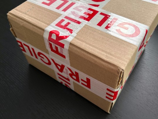 Ett brunt paket med texten "FRAGILE" i rött.