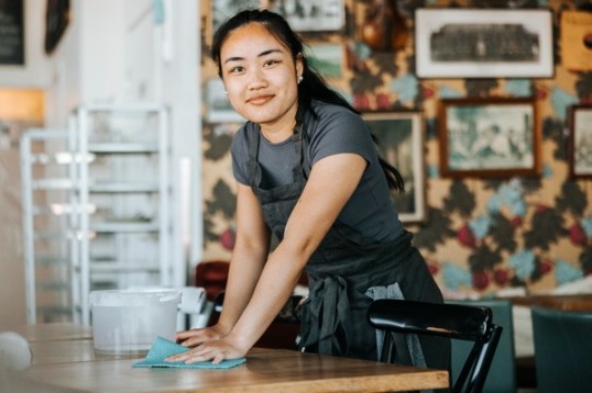 En ungdom som startat sitt arbetsliv på ett kafé.